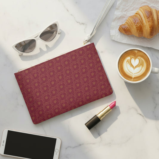Red and black patterned pouch with makeup items on a pink background